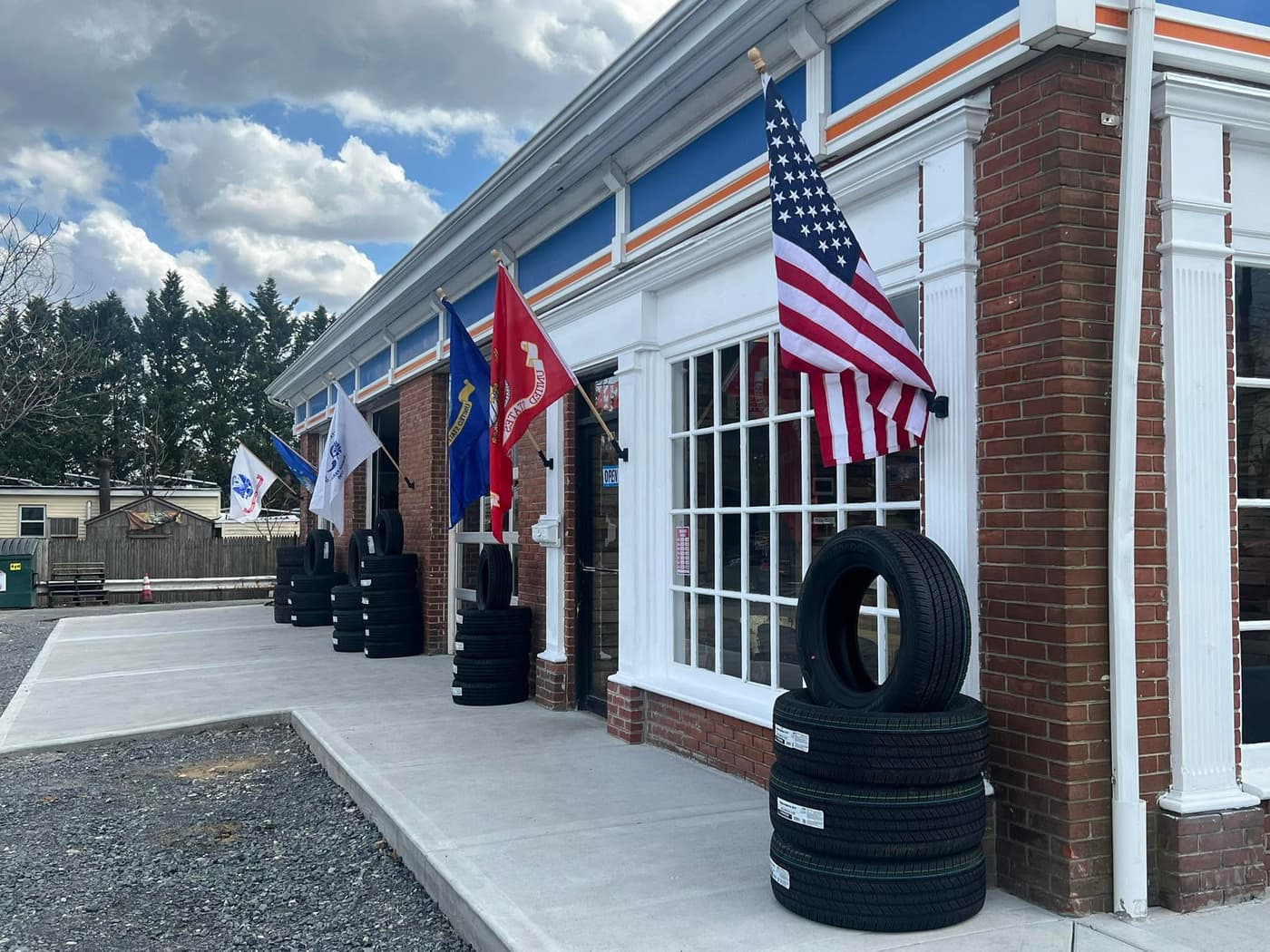 Front of the brick shop with flags and stacked tires