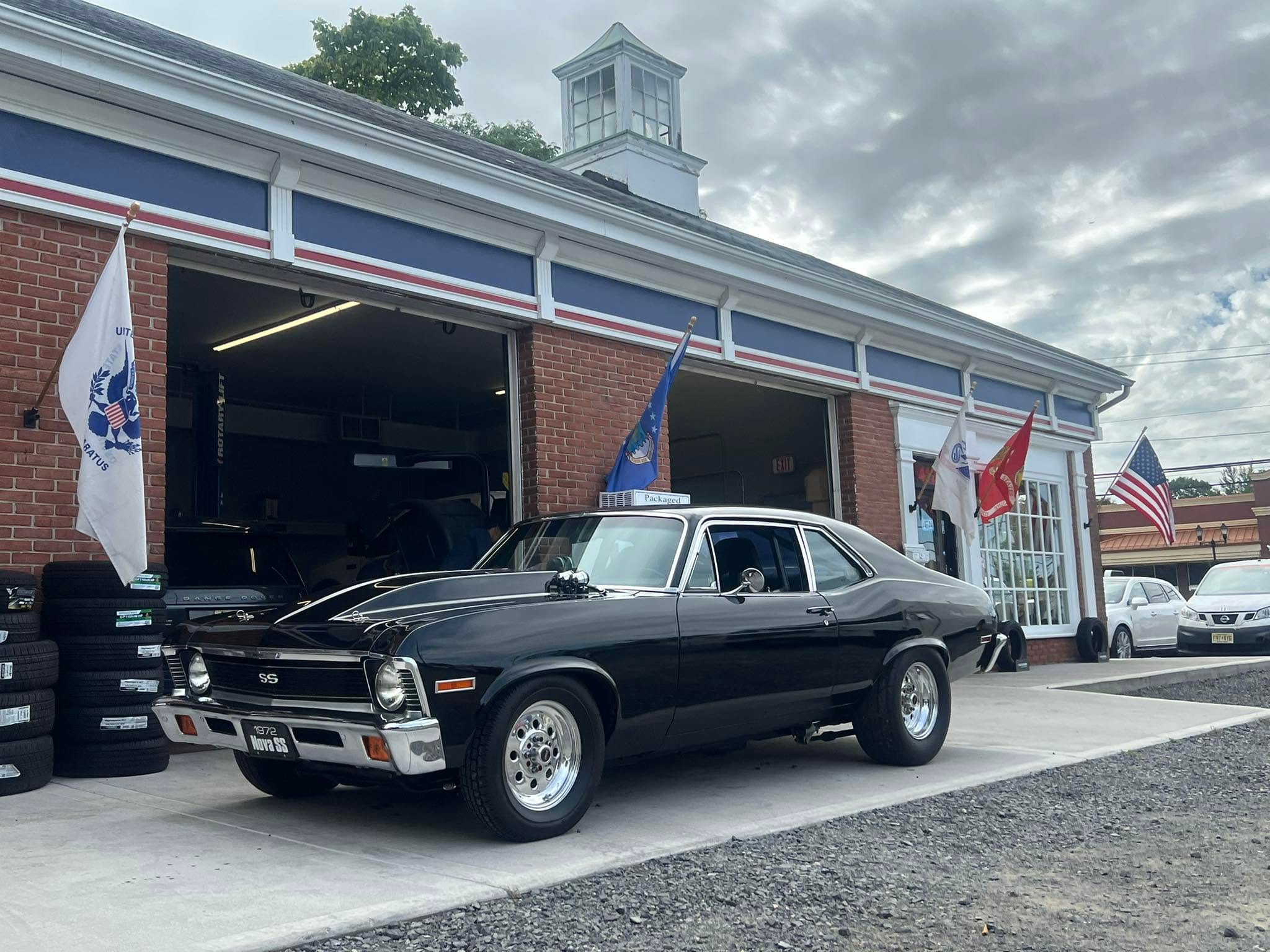 A black 1972 Chevy Nova in front of the shop on Route 36